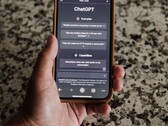 Egy kéz, amelyben egy okostelefon van, rajta a ChatGPT felületével
