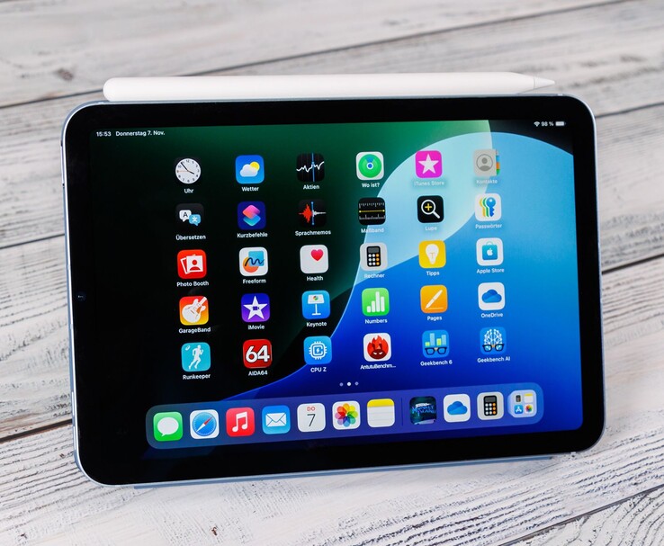 Egy iPad mini előlapja, rajta a Apple Pencil, a kezdőképernyő egy fafelületre helyezve. (Kép forrása: Notebookcheck)