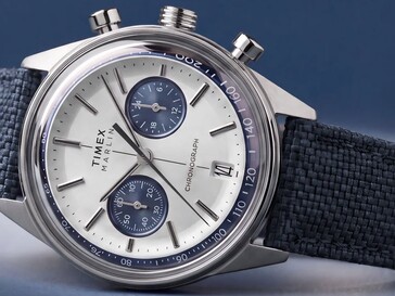 A Timex Marlin Jet Chronograph sötét háttér előtt fényképezve, látható a domború üvege, a tachyméter kerete, a homorú számlapja, a kronográf kis számlapjai és a retro-futurisztikus tok kialakítása.