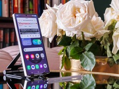 Egy asztalon függőlegesen álló Samsung Galaxy S25 Ultra, amelynek kijelzőjén egy megnyitott weboldal látható