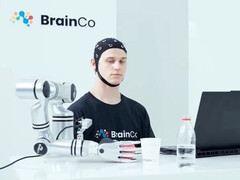 A BrainCo gondolatvezérléses technológiáját használó felhasználó pusztán gondolatával, mintha robot lenne, megragad egy almát.