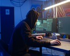 Általános hacker egy kétmonitoros munkaállomáson, amint ellátási láncot érintő támadást hajt végre.