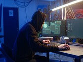 Általános hacker egy kétmonitoros munkaállomáson, amint ellátási láncot érintő támadást hajt végre.