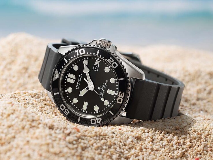 A Citizen Promaster Marine BN0266-07E modell fekete számlappal, fekete kerettel és fekete szíjjal a homokon fekszik.