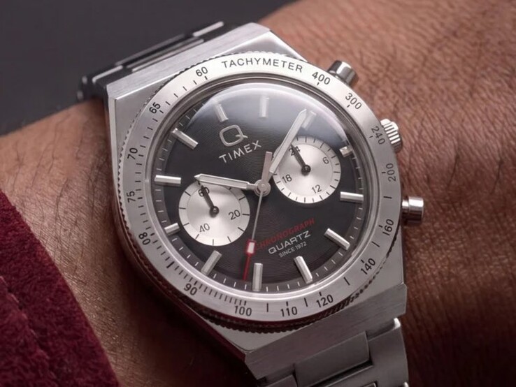 A csuklón viselt Timex Q Timex Continental Chronograph TW2Y93200 modell fekete, sugárirányú CD-stílusú számlappal, két ezüst színű kis számlappal, tachyméter kerettel, világító jelölésekkel és integrált rozsdamentes acél karkötővel rendelkezik.