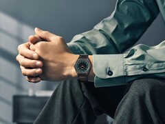 A Citizen Eco-Drive One AR5065-54W modell a csuklón, erdőzöld és fekete számlappal, rózsaszín arany díszítéssel és ultravékony, fekete bevonatú karkötővel.