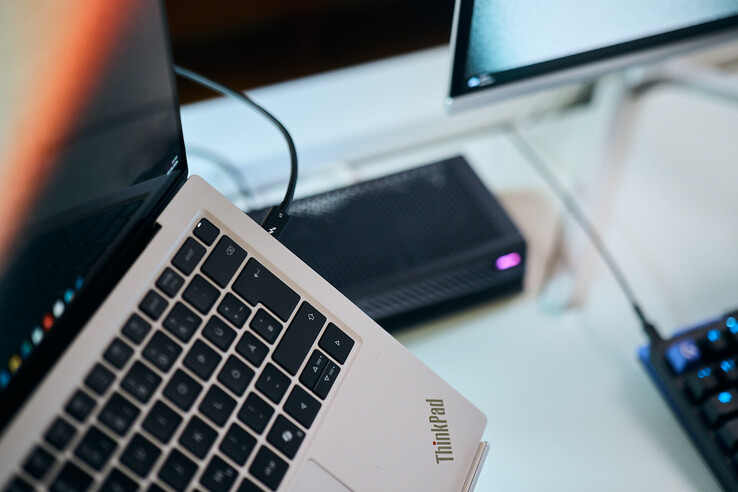 Makrófelvétel egy Thunderbolt 5 kábleről, amely egy Lenovo ThinkPad X9 laptop oldalsó portjába van csatlakoztatva, háttérben az Aorus eGPU-val.
