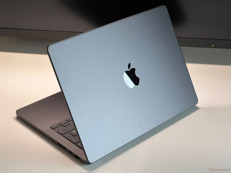 Apple Space Grey színű MacBook Pro egy asztalon, részben nyitott fedéllel, a billentyűzet és a Apple logó látható (Kép forrása: Notebookcheck)