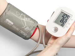 Egy személy egy orvosi tonométert használ (Kép forrása: Mockup Graphics via Unsplash; kivágva)