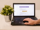 Asztalon álló laptop, amelyen egy megnyitott e-mail beérkező levelek mappa látható, mellette egy cserepes növény.