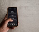 Egy kéz egy okostelefont tart, amelyen a ChatGPT felülete látható, egy szürke kőfelület felett