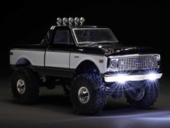 Az Axial SCX24 lánctalpas kép sötét háttér előtt.