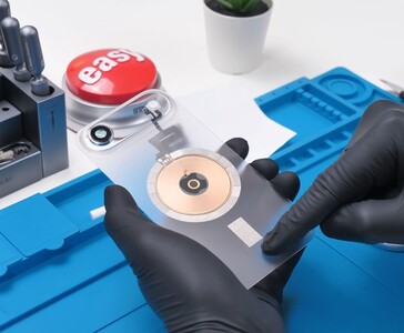 Átlátszó iPhone Air hátsó üveg, látható réz vezeték nélküli töltőtekercs és kameramodul a modding folyamat során. (Kép forrása: Phone Repair Guru via YouTube)