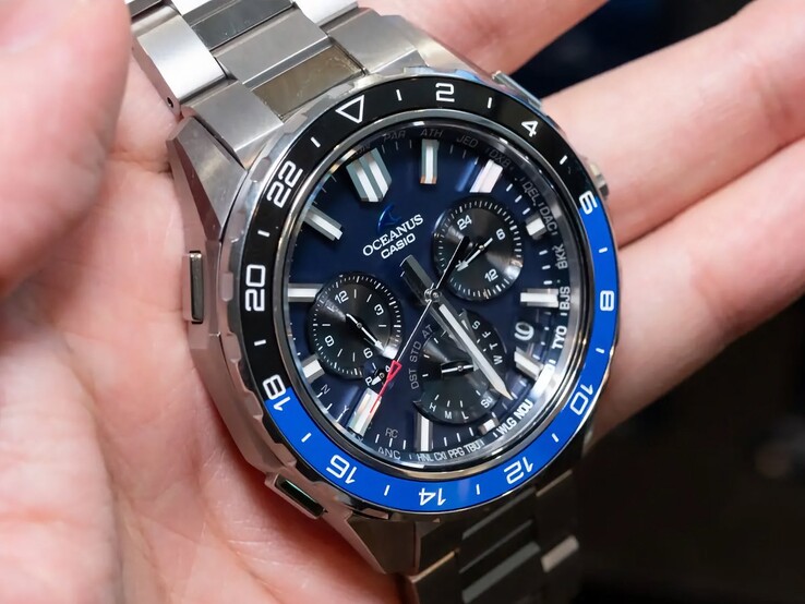 A Casio Oceanus OCW-P3000 kék számlapjának közelképe, amelyen láthatók a városkódok, a kis számlapok, a világító órajelölők és a széles mutatók.