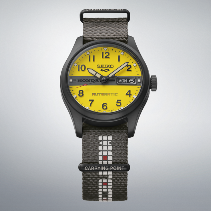 A Seiko 5 Sports Field x Honda Motocompo Limited Edition óra elölnézete: sárga számlappal, középen fekete Honda logóval és szürke nejlon szíjjal.