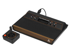 Egy retro videojáték-konzol, az Atari 2600, egyszerű fehér háttér előtt fényképezve. (A kép forrása: Evan-Amos a Wikimedia Commonson)