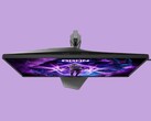 A képen az AOC AG276UZ gamer monitor látható lila háttér előtt. A gamer monitor kifejezetten játékos kialakítású, hátulján RGB-megvilágítással.