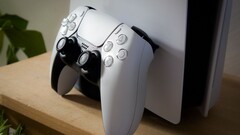 Egy PS5 konzolnak támasztott PlayStation 5 DualSense kontrollert ábrázoló kép