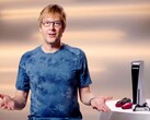  Mark Cerny egy PlayStation eseményen, egy PS5 konzol és DualSense kontrollerek mellett ülve. (Kép forrása: Sony Interactive Entertainment)