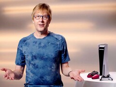  Mark Cerny egy PlayStation eseményen, egy PS5 konzol és DualSense kontrollerek mellett ülve. (Kép forrása: Sony Interactive Entertainment)