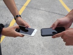 Két ember két okostelefont tart egymás mellett egy átadás során