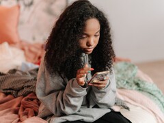 Tinédzser okostelefont használ egy ágyon, a ChatGPT for Teens és a szülői felügyelet szimbolikus képe