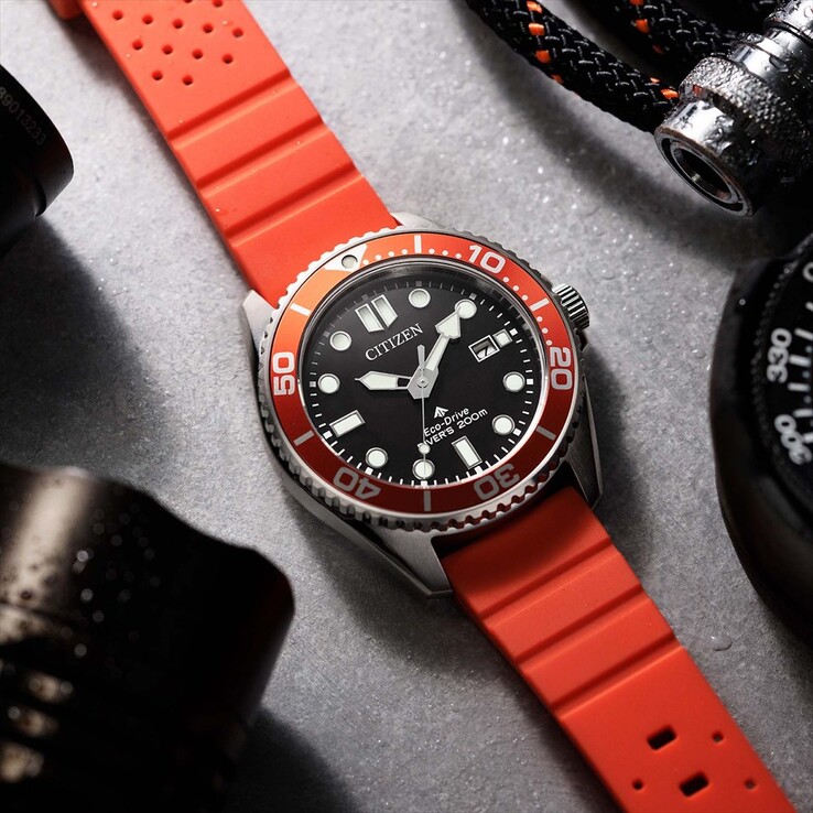Citizen Promaster Marine BN0268-01E búváróra fekete számlappal, narancssárga kerettel és narancssárga szíjjal, texturált felületen fényképezve.