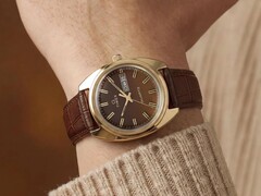 Timex Q 1978 Day and Date barna fumé számlappal és aranyszínű tokkal, csuklón bemutatva, barna bőrszíjjal.