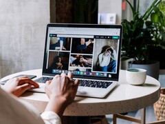 Egy kávézóban laptopon gépelő személy, a képernyőn egy böngészőablak a lapok sávjával és a címsávval