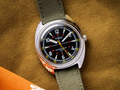 A Timex x Bespoke Post limitált kiadású 36 mm-es karóra, a képen olajzöld Cordura szíjjal, sötét mustárszínű háttér előtt. (Kép forrása: Timex)