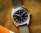 A Timex x Bespoke Post limitált kiadású 36 mm-es karóra, a képen olajzöld Cordura szíjjal, sötét mustárszínű háttér előtt. (Kép forrása: Timex)