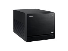 A képen a Shuttle XPC Mini PC fejből látható, amely egy fekete kockának látszik, minimális dizájnnal. 