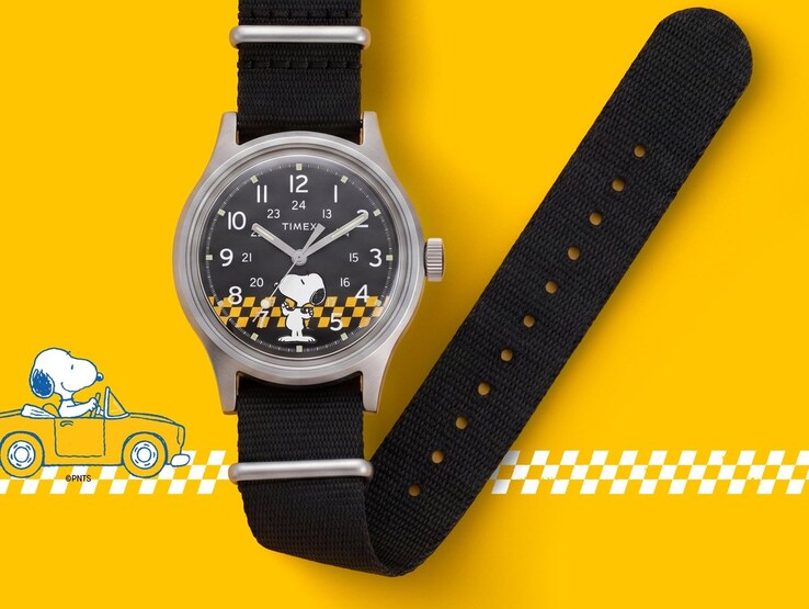 Peanuts x Timex MK1 karóra fekete számlappal, Snoopy-val és sárga-fekete kockás mintával, fekete szövet szíjjal, sárga háttér előtt.