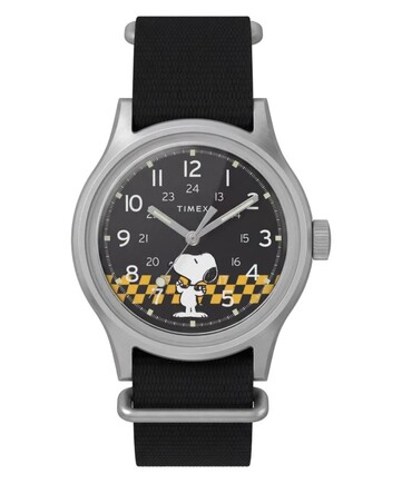 A Peanuts x Timex MK1 elölnézete, amelyen látható a fekete számlap, az arab számok, a világító mutatók és jelölések, valamint a kockás Snoopy-grafika.