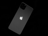 Egy iPhone hátulja, fekete háttér előtt az Apple logóval