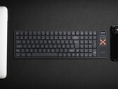 Iqunix Magi96 vezeték nélküli mechanikus billentyűzet egy íróasztalon más műszaki eszközökkel együtt