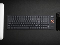 Iqunix Magi96 vezeték nélküli mechanikus billentyűzet egy íróasztalon más műszaki eszközökkel együtt