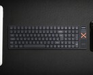 Iqunix Magi96 vezeték nélküli mechanikus billentyűzet egy íróasztalon más műszaki eszközökkel együtt