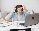 Fejhallgatót viselő férfi frusztráltan emeli fel a kezét egy laptop előtt