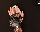 Egy barkács exoskeleton eszköz a kézre szíjazva, miközben egy játékegeret használ (Kép forrása: Basically Homeless/YouTube)