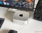 Apple M6 Mac mini egy íróasztalon, játékkonfigurációban, monitorral, billentyűzettel, egérrel és hangszóróval.