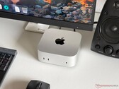 Apple M6 Mac mini egy íróasztalon, játékkonfigurációban, monitorral, billentyűzettel, egérrel és hangszóróval.