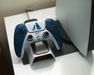Egy egyedi, God of War-témájú DualSense kontroller egy töltődokkolóban, egy PlayStation 5 konzol előtt. (Kép forrása: FOX ^.ᆽ.^= ∫)