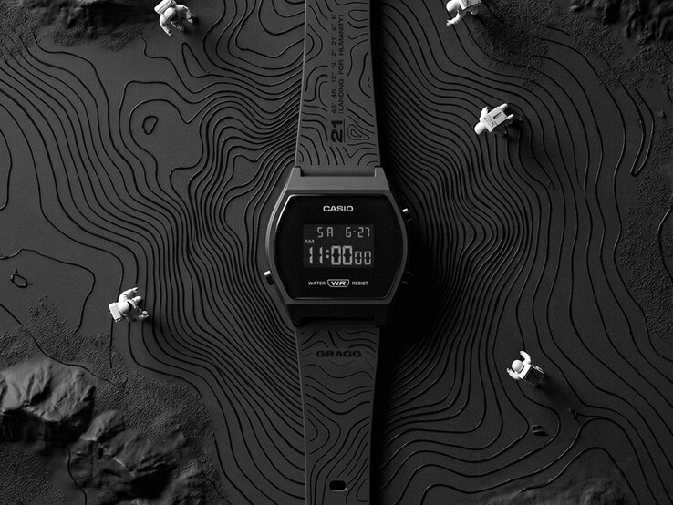 A Casio x GRAGG LW-204GRAGG-1BDF modell közelképe, amelyen látható a fekete műanyag szíj, amelyre kontúrvonalakból álló grafika van gravírozva.
