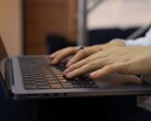 Egy sötét laptop billentyűzetén gépelő kezek