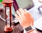 Homokóra egy laptop billentyűzetén ülő kéz mellett