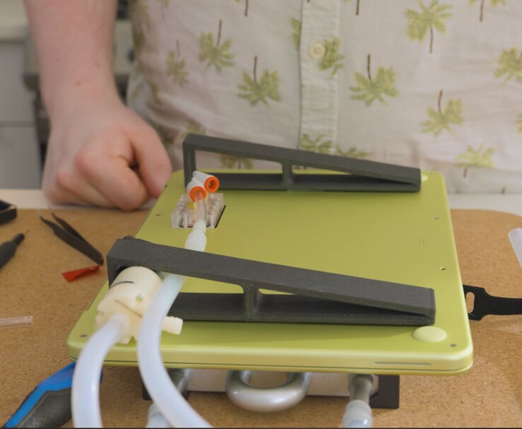 Módosított MacBook Neo külső szivattyúval és csövekkel a DIY folyadékhűtés beállításához