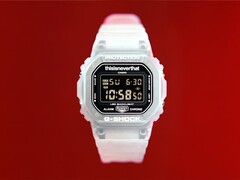 Casio G-Shock DW-5600TNT-7 x thisisneverthat karóra, áttetsző műanyag tokban és szíjjal, piros háttér előtt.