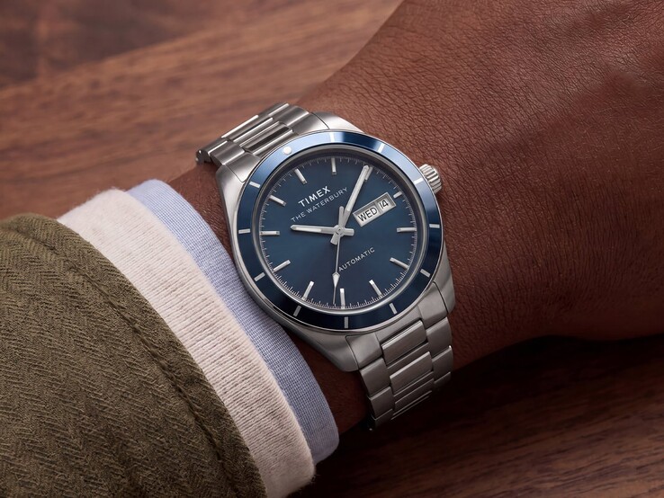 A csuklón viselt Timex Waterbury Heritage Automatic kék zománc számlappal, amelyen látható az ezüstszínű tok és a rozsdamentes acél karkötő.