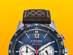 A Citizen Racing Chronograph CA4716-09L közelképe, amelyen látható a kék tachyméter keret, a mélykék számlap ezüstszínű mutatókkal és jelölésekkel, a három kis számlap, a piros központi másodpercmutató, valamint a barna, perforált bőr szíj sárga háttér előtt.